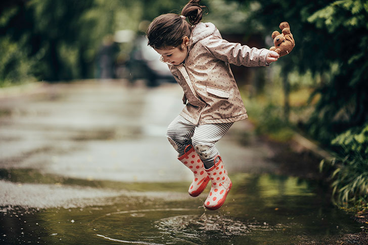 Girl jumping in a puddle